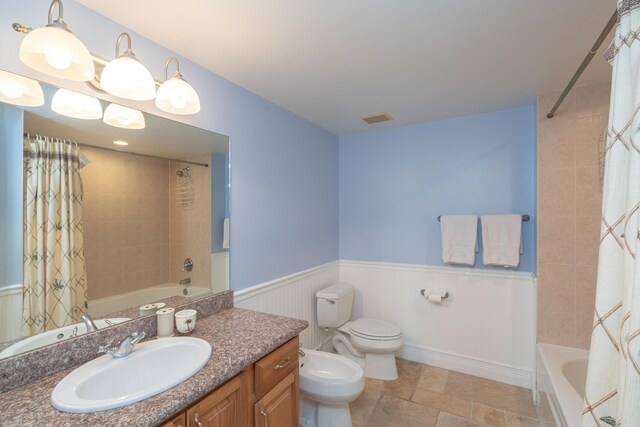 full bathroom with a bidet, vanity, toilet, and shower / tub combo with curtain