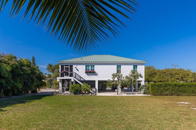 261 W Seaview Dr, Duck, FL 33050 - rear view of house featuring stairs, a yard, and metal roof