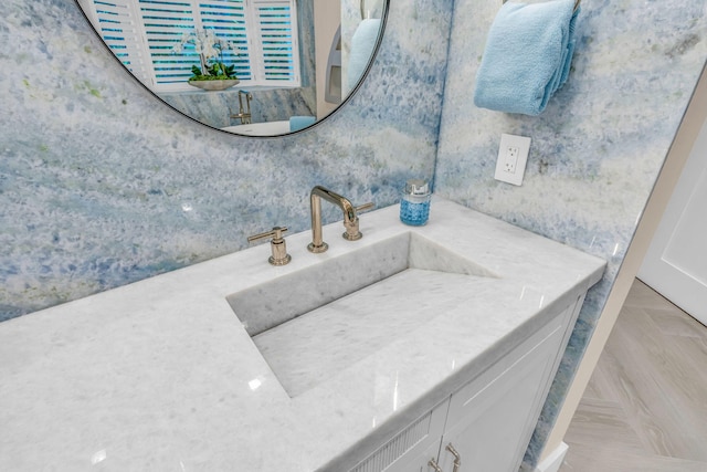 bathroom featuring parquet floors and vanity