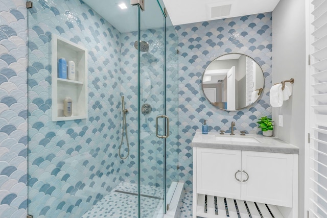 bathroom featuring walk in shower and vanity