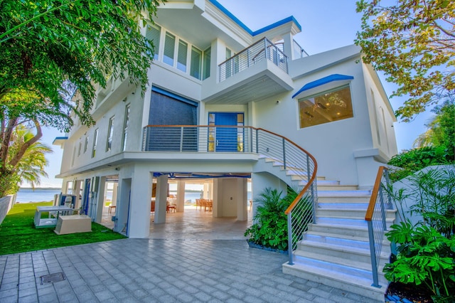 rear view of property featuring a balcony and a carport