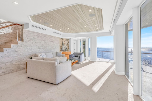 living room with a raised ceiling and a water view