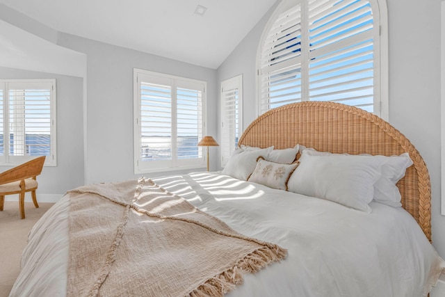 carpeted bedroom with multiple windows and lofted ceiling