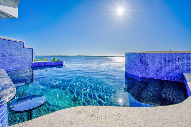 view of swimming pool featuring a water view