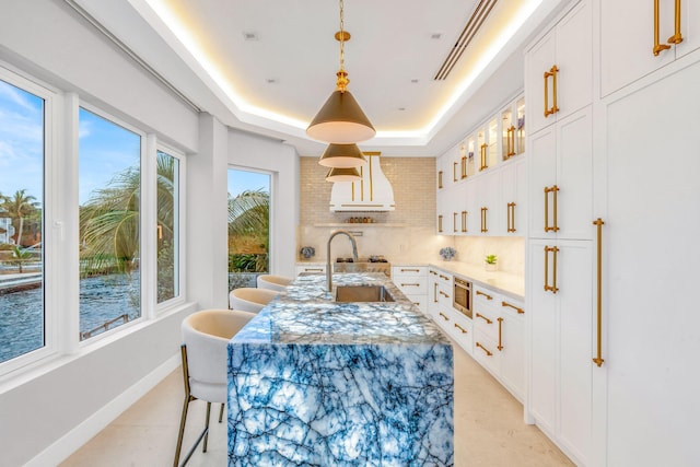 dining room featuring sink and a raised ceiling