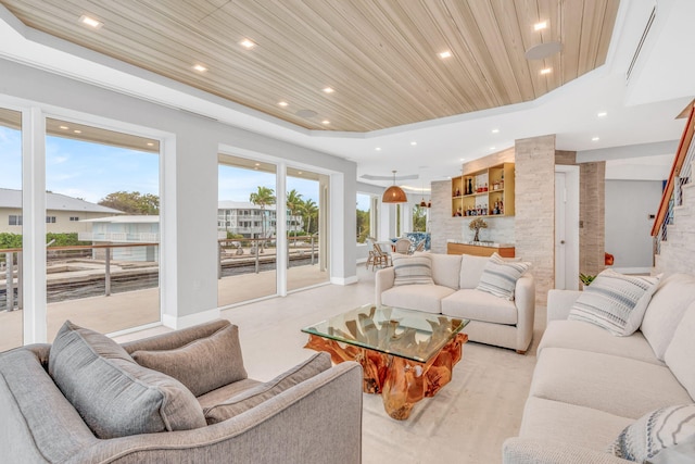 living room featuring a raised ceiling, bar, and wood ceiling