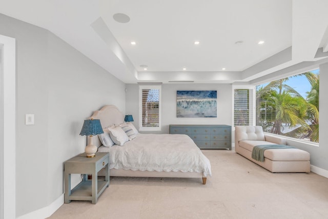 bedroom with a tray ceiling and multiple windows