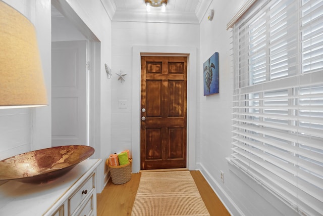 entryway featuring ornamental molding and light wood-style floors