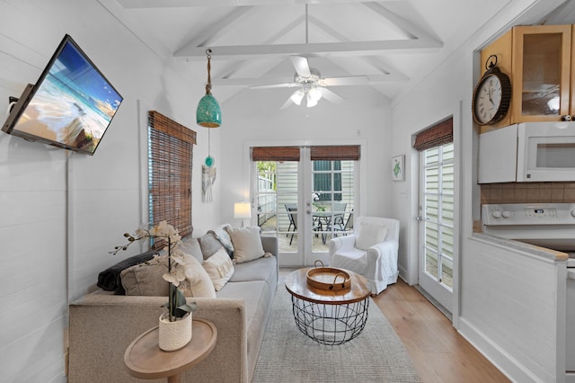 living room featuring lofted ceiling with beams, light wood-style floors, and ceiling fan