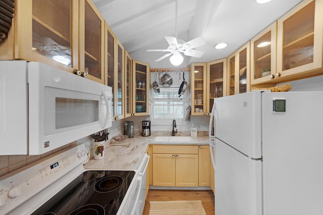 kitchen featuring glass insert cabinets, white appliances, light countertops, and a sink