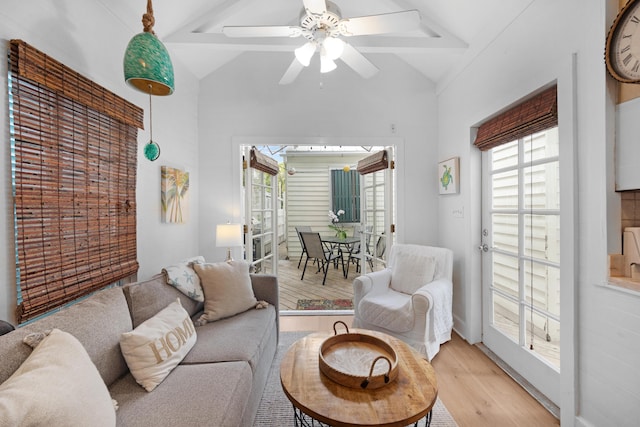 living area with high vaulted ceiling, light wood-style flooring, and a ceiling fan