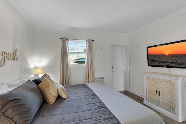 bedroom featuring baseboards, ornamental molding, and wood finished floors