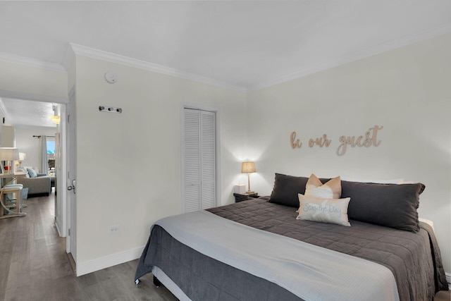 bedroom featuring a closet, ornamental molding, baseboards, and wood finished floors