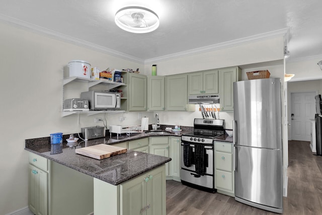 kitchen featuring a peninsula, stainless steel appliances, under cabinet range hood, a sink, and green cabinetry