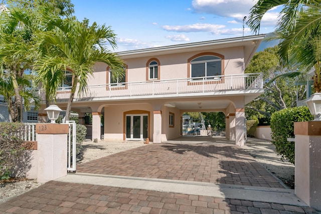 back of house featuring a balcony and french doors