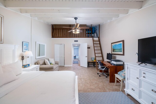 bedroom featuring beamed ceiling, a high ceiling, and light tile patterned floors