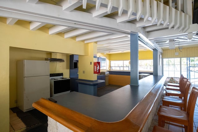 kitchen featuring white refrigerator, a wealth of natural light, electric range, and beam ceiling