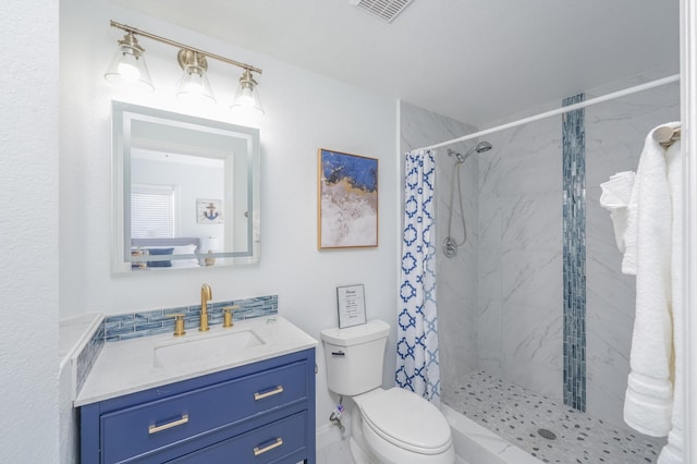 bathroom featuring toilet, visible vents, vanity, and a stall shower