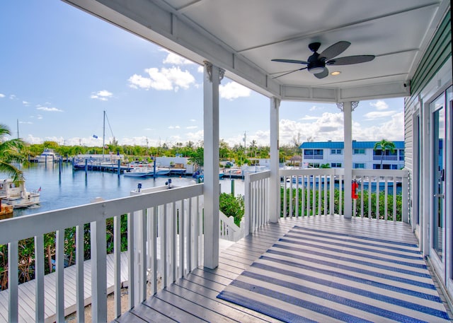 wooden deck featuring a ceiling fan and a water view
