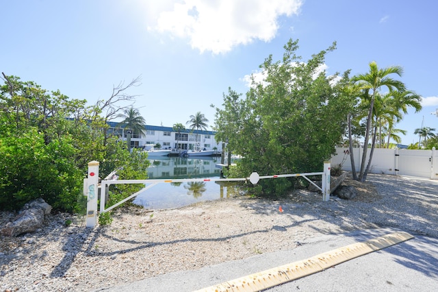 exterior space featuring fence, a gate, and a water view