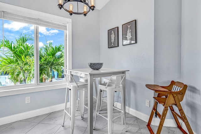 dining room with a chandelier, marble finish floor, and baseboards