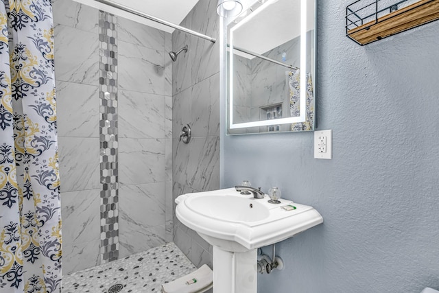 full bathroom with a stall shower and a textured wall