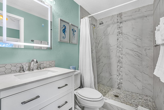 full bathroom featuring a stall shower, toilet, a textured wall, and vanity