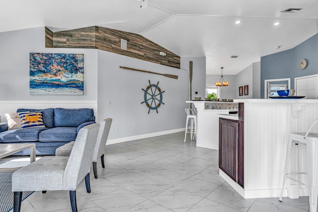 dining area featuring lofted ceiling, a notable chandelier, and marble finish floor