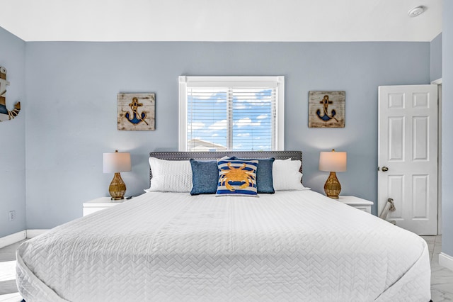 bedroom featuring marble finish floor and baseboards