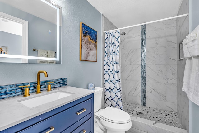 full bath with vanity, toilet, a textured wall, and tiled shower