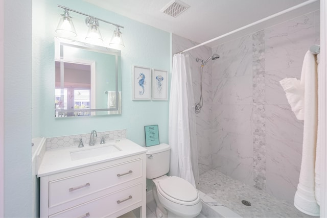 bathroom with vanity, visible vents, toilet, and a stall shower