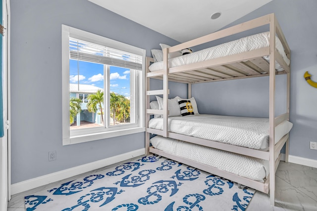 bedroom with marble finish floor and baseboards
