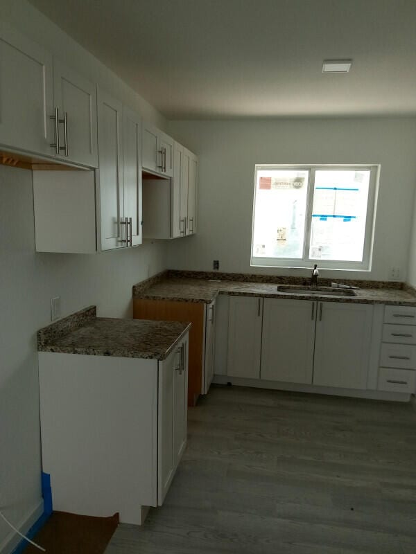 10877 Overseas Hwy Unit 85, Marathon, FL 33050 - kitchen featuring a sink, light wood-type flooring, and white cabinets