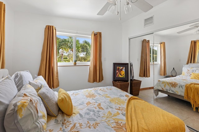 tiled bedroom featuring ceiling fan and a closet