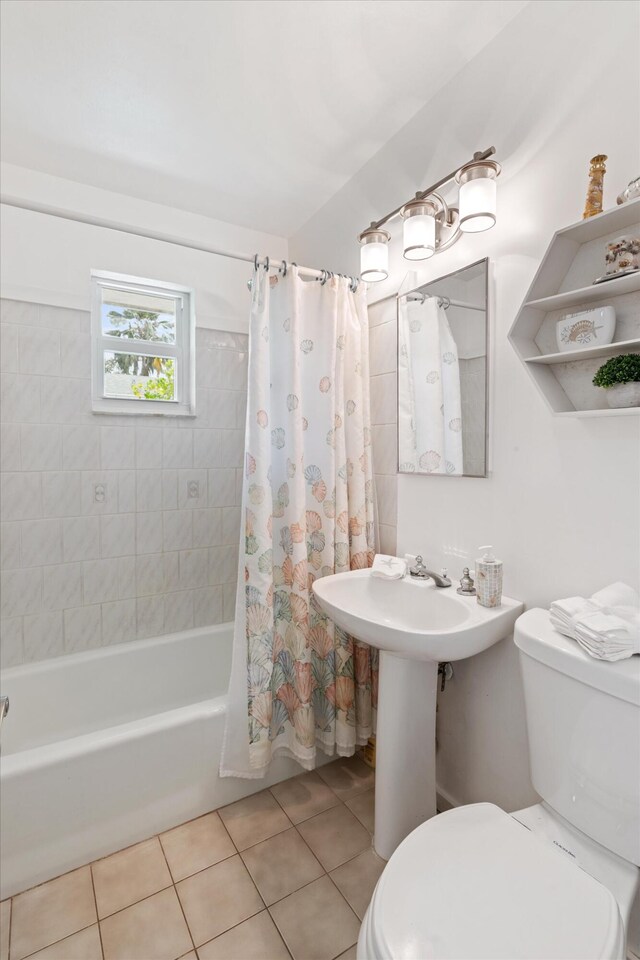 bathroom featuring tile patterned flooring, shower / bath combination with curtain, and toilet