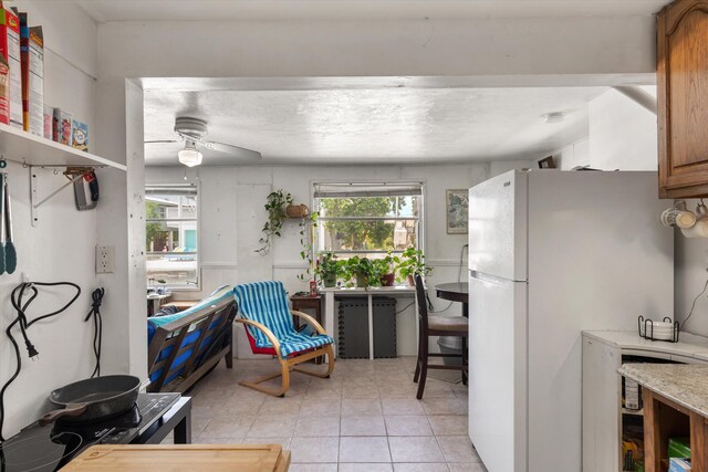 kitchen featuring white refrigerator, light tile patterned floors, and ceiling fan