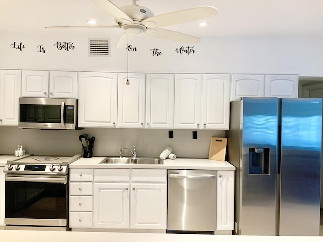 kitchen featuring ceiling fan, appliances with stainless steel finishes, sink, and white cabinets