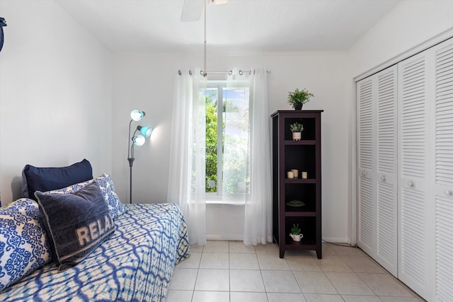 tiled bedroom with multiple windows, crown molding, a closet, and ceiling fan