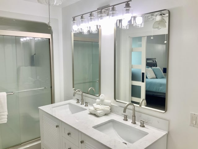 bathroom with vanity and a shower with door