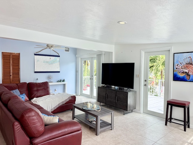 living room featuring light tile patterned floors, french doors, a textured ceiling, and ceiling fan