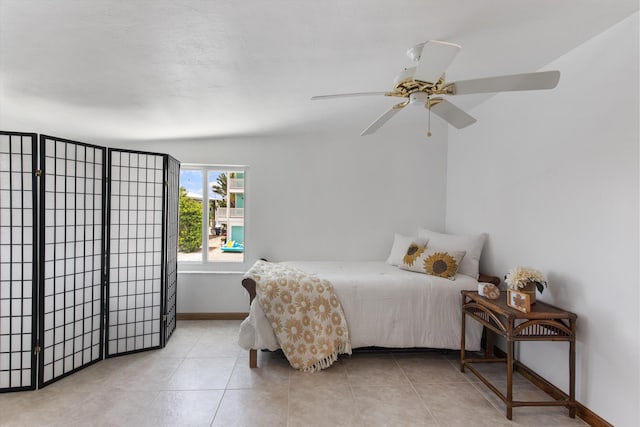 tiled bedroom featuring ceiling fan