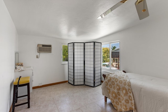 bedroom featuring a wall unit AC and a textured ceiling