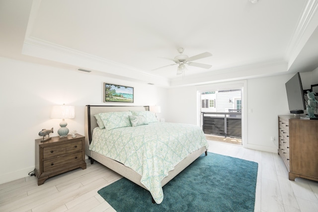 bedroom featuring ceiling fan, ornamental molding, a raised ceiling, and light wood-type flooring