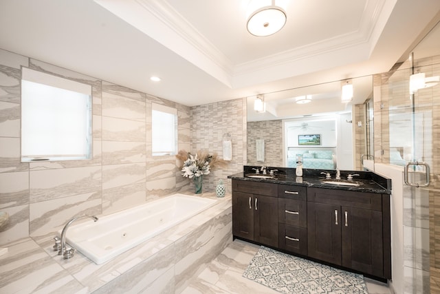 bathroom featuring plus walk in shower, tile walls, vanity, a tray ceiling, and crown molding