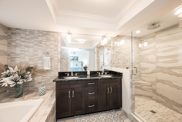 bathroom featuring tile walls, a tray ceiling, a shower with shower door, and ornamental molding