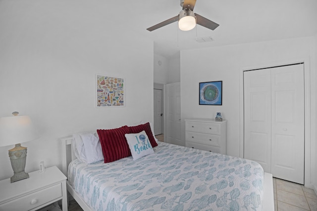 tiled bedroom with ceiling fan and a closet