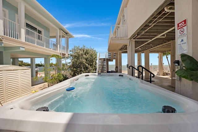 view of pool with a hot tub