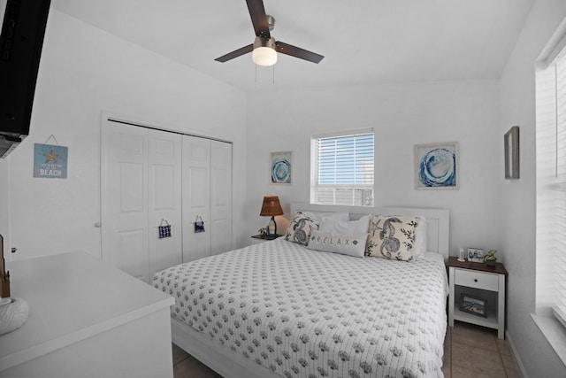 tiled bedroom featuring ceiling fan and a closet