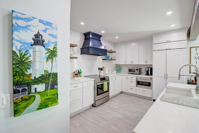 kitchen featuring open shelves, custom exhaust hood, stainless steel electric stove, a sink, and white cabinetry