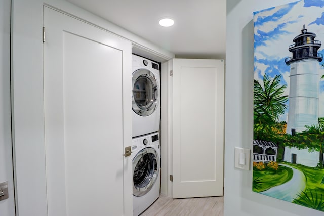 laundry area with laundry area, recessed lighting, stacked washing maching and dryer, and light wood-style floors